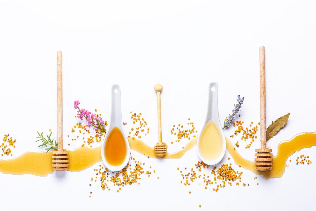 white spoons honey sticks with spilled honey scaled