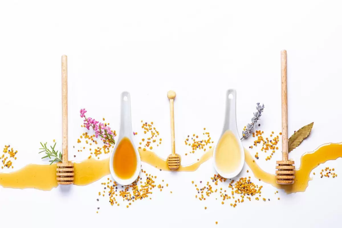 white spoons honey sticks with spilled honey scaled